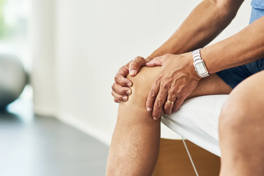 adult examines knee in doctor s office setting 2026 01 09 11 36 30 utc