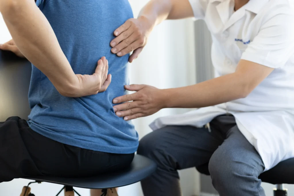 doctor examines patient s back in office setting 2026 03 24 07 59 16 utc