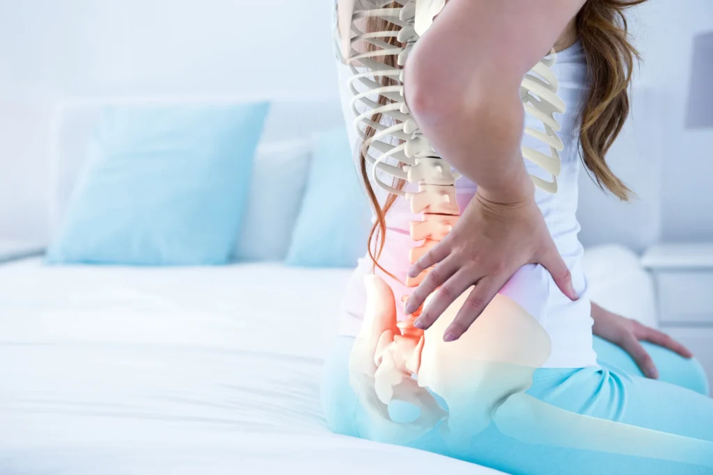 woman holding lower back in pain on bed 2026 03 26 11 49 34 utc