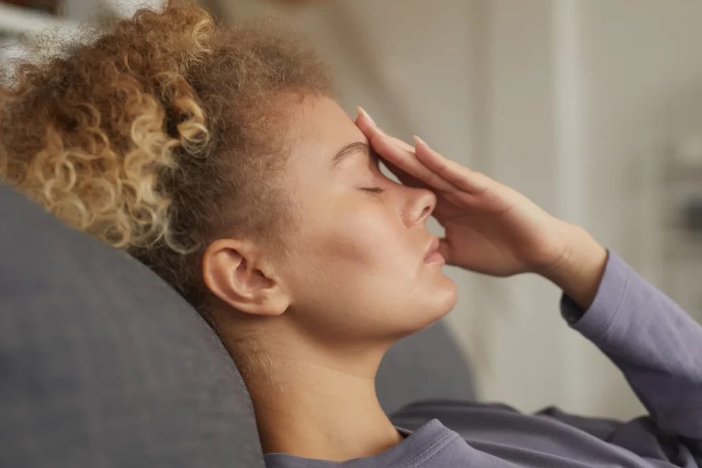 woman with curly hair holding forehead eyes close 2026 03 18 17 42 06 utc